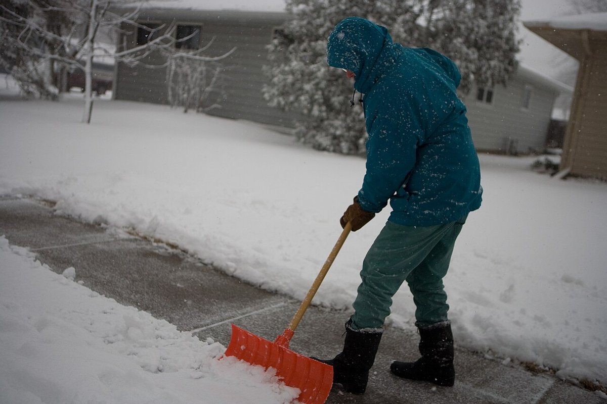 Person shoveling snow from a residential sidewalk