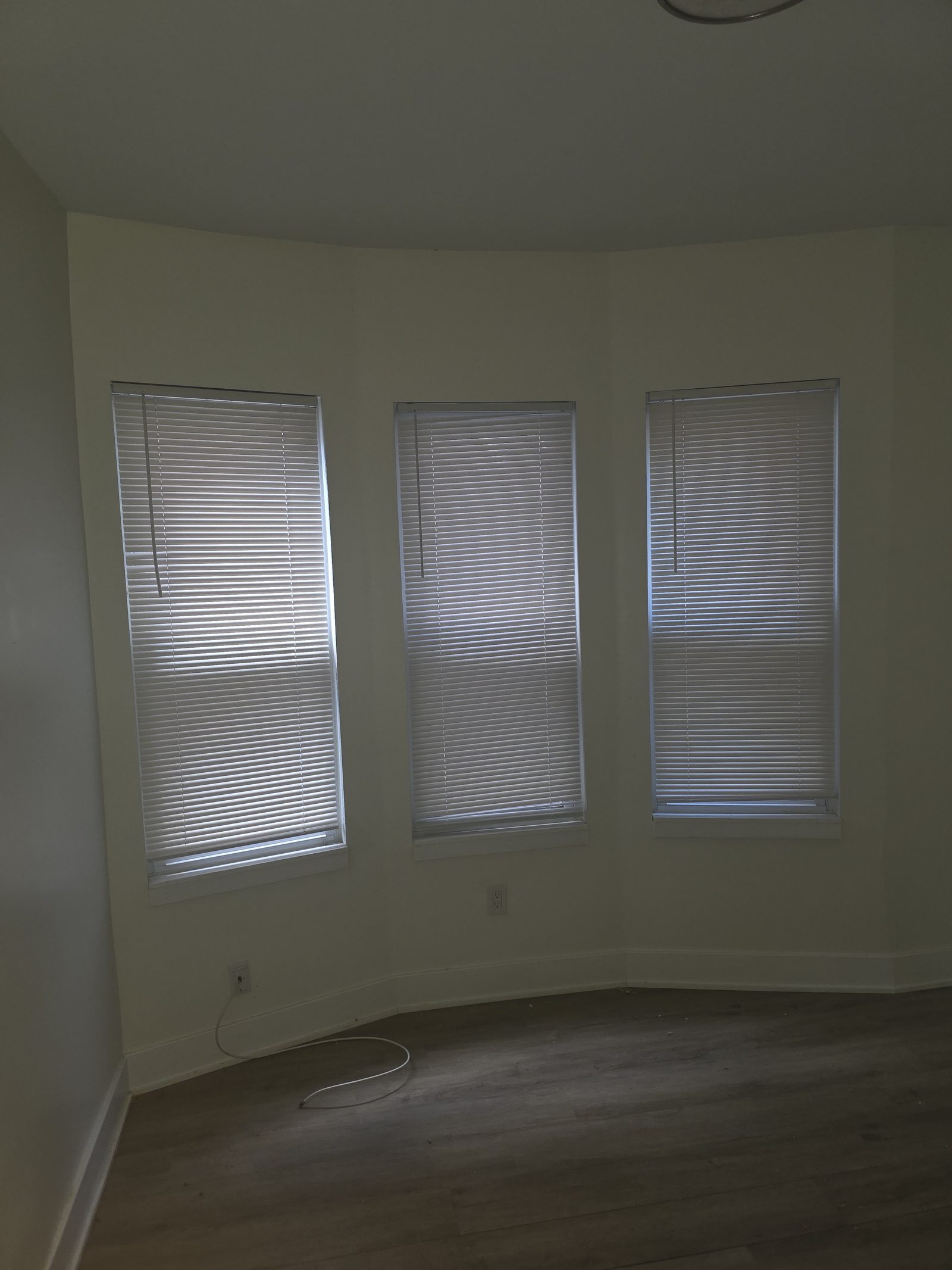 Freshly painted bay-window room with new flooring
